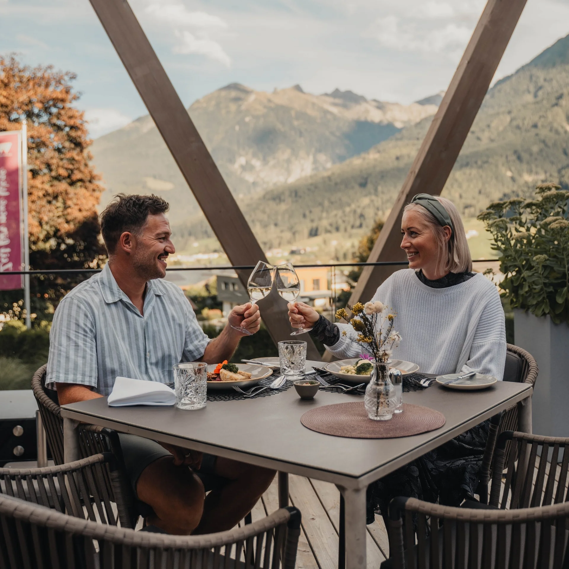 Couple toasting with white wine outdoors with mountain view