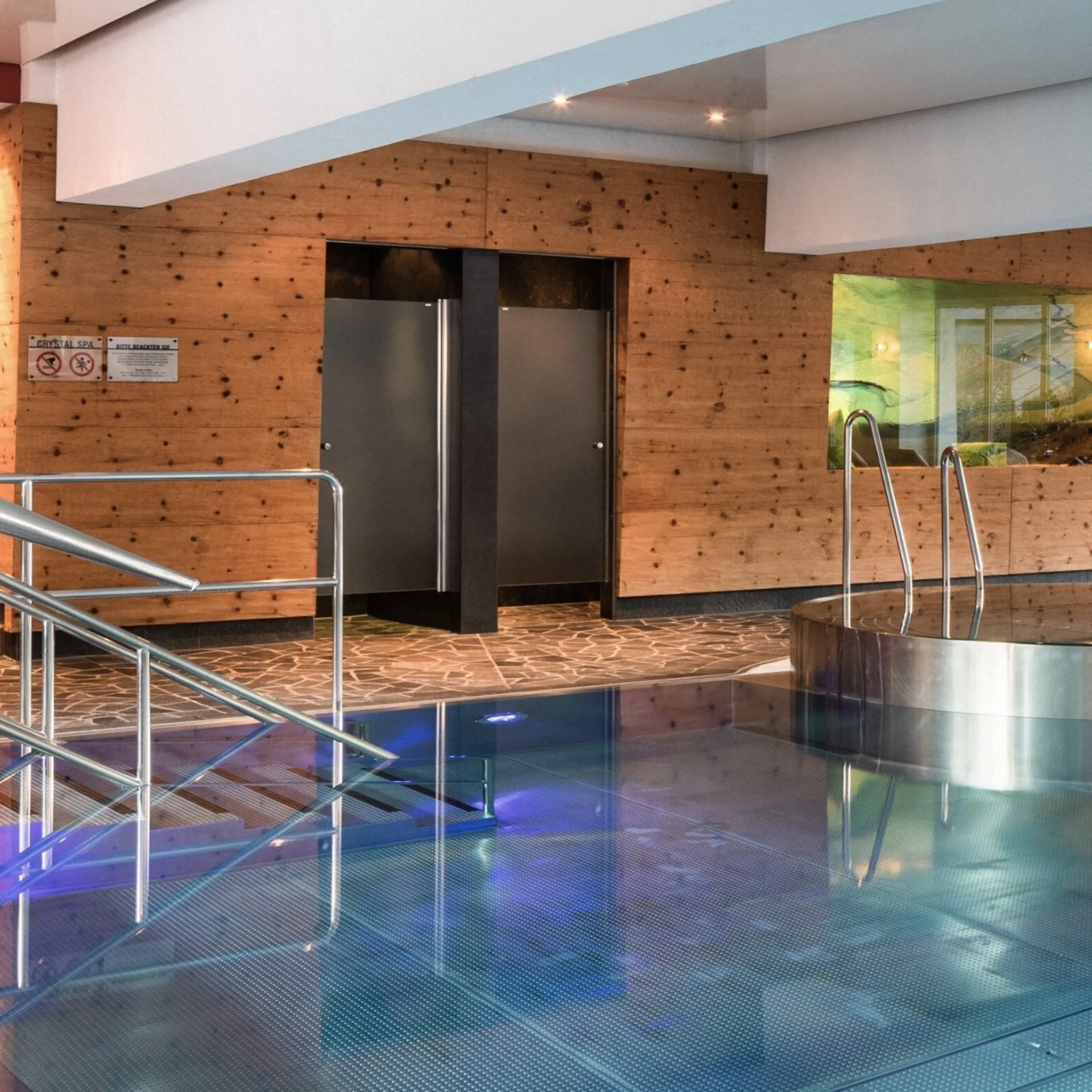 Moderner Wellnessbereich mit Innenpool und Holzverkleidung an den Wänden