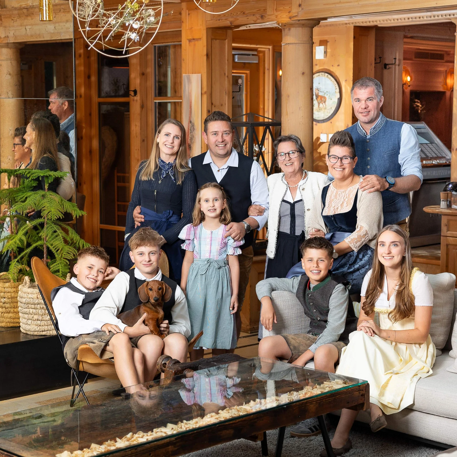 Welcome.Back A family with a dog poses in a cozy wood-paneled room