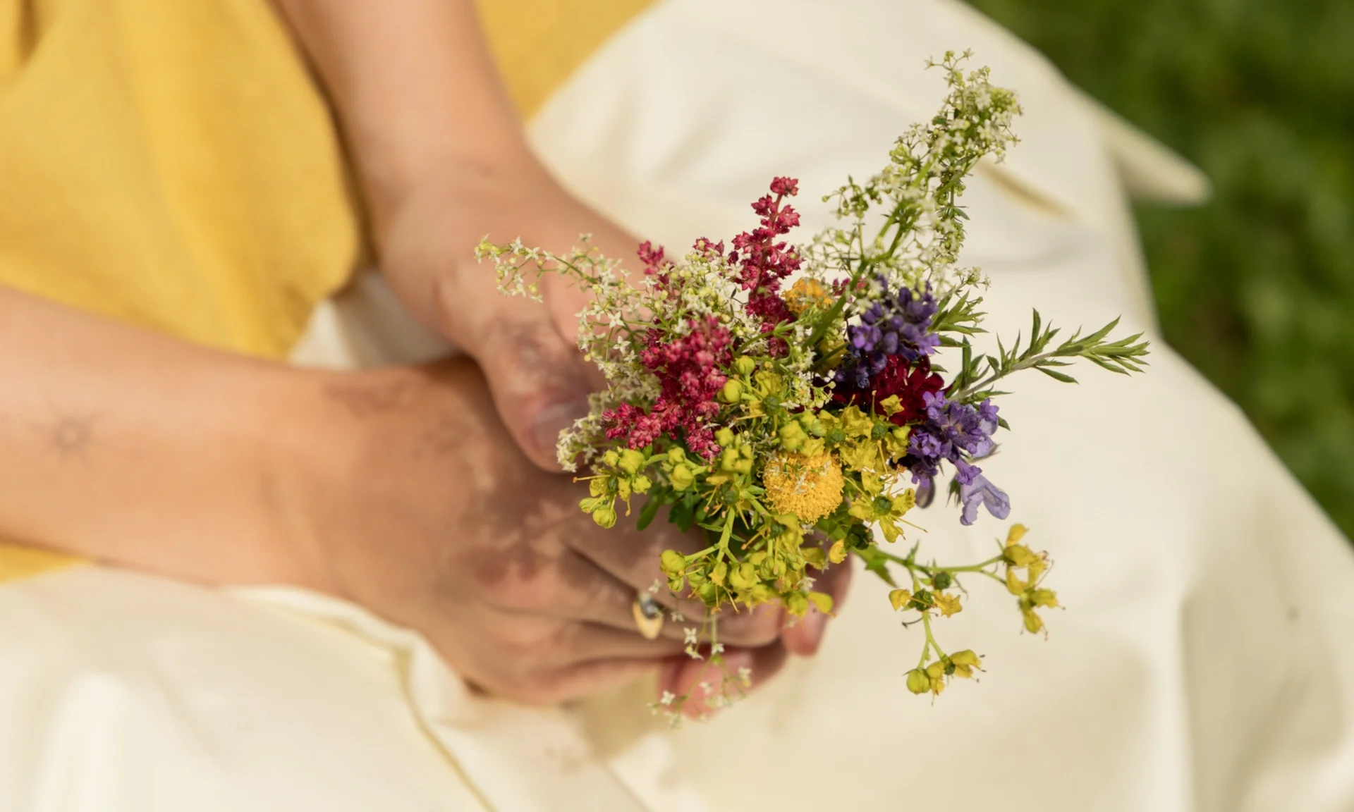 Home Person hält einen bunten Frühlingsblumenstrauß in der Hand