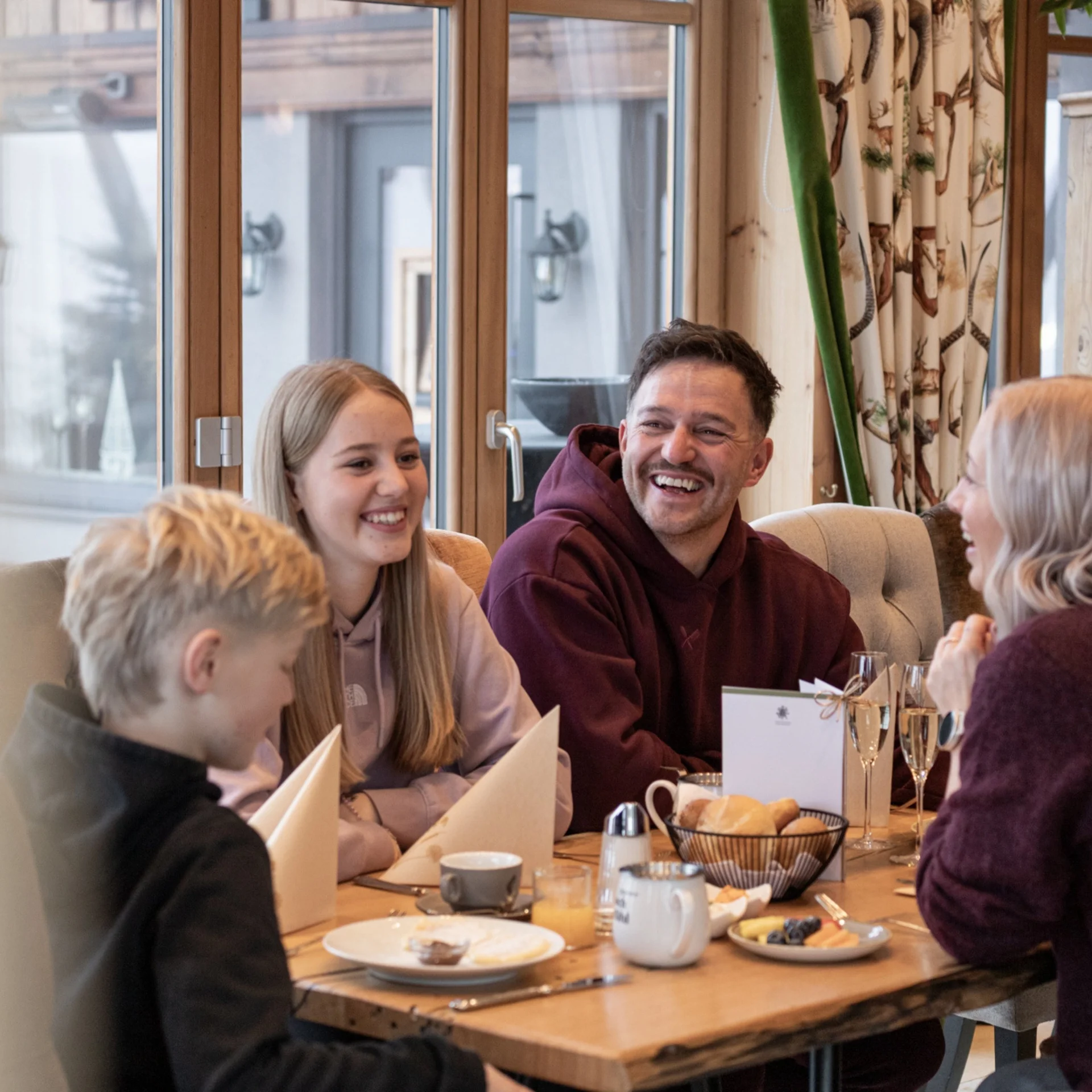 Feel.Eggstra-Good A group laughs together over breakfast at a set table
