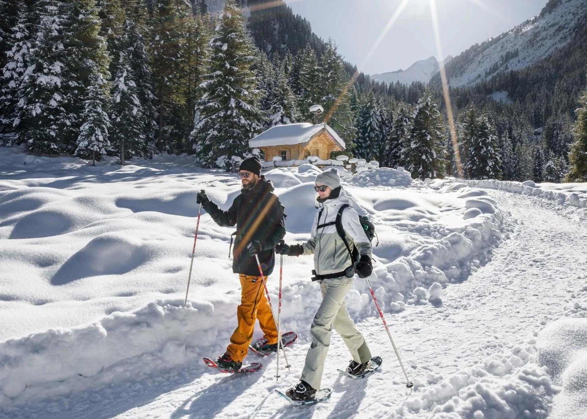 Wanderhotel Zwei Personen beim Schneeschuhwandern in sonniger verschneiter Berglandschaft