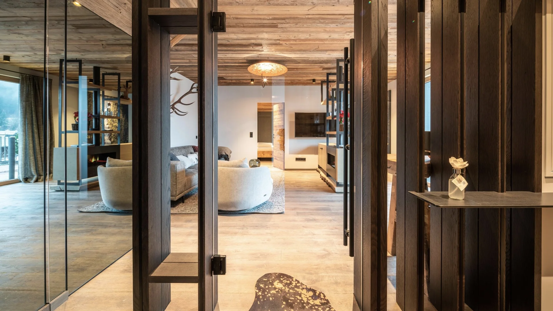 Babymoon im Gassner Baumhaus Moderner Wohnraum mit Holzdecken, Glaswänden und gemütlichen Möbeln