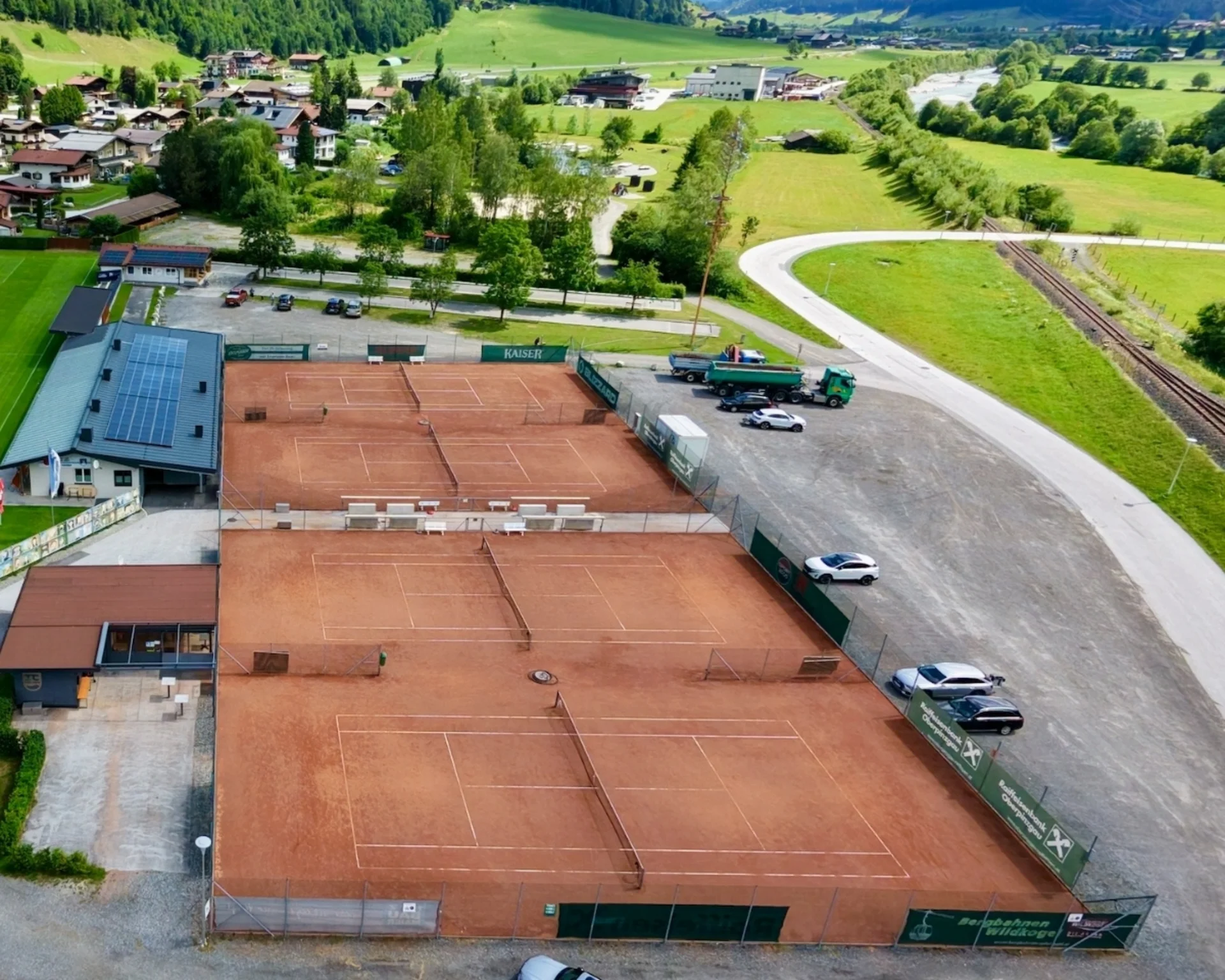 Excursion tips Aerial view of tennis courts with mountains and village in the background
