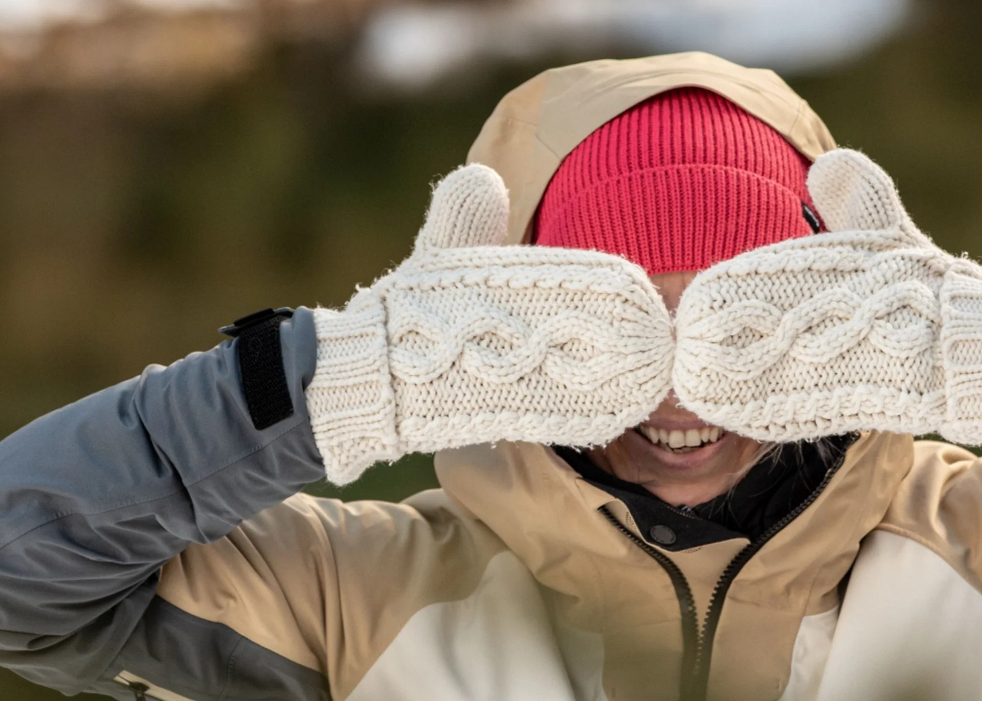 Person mit roter Mütze und weißen Handschuhen zeigt Daumen nach oben