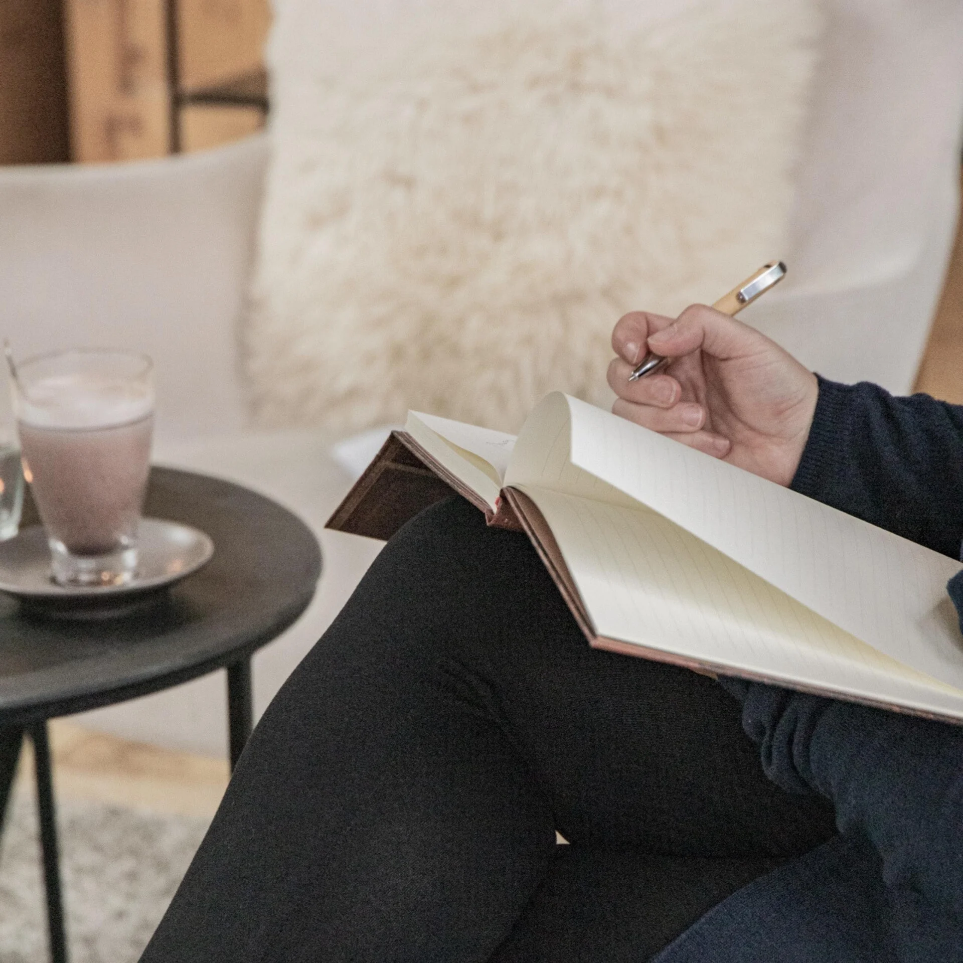 Ein Blick zurück Person sitzt und hält Stift über offenem Notizbuch auf dem Schoß