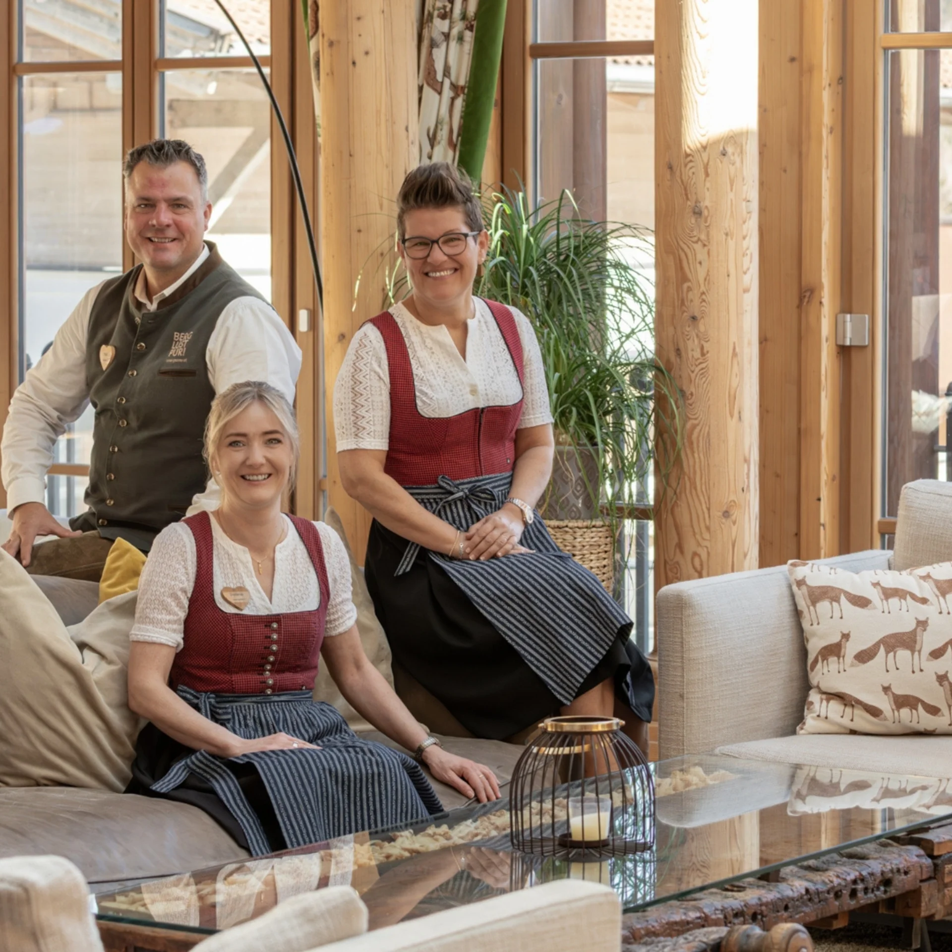 Four people in traditional attire in a wooden interior room