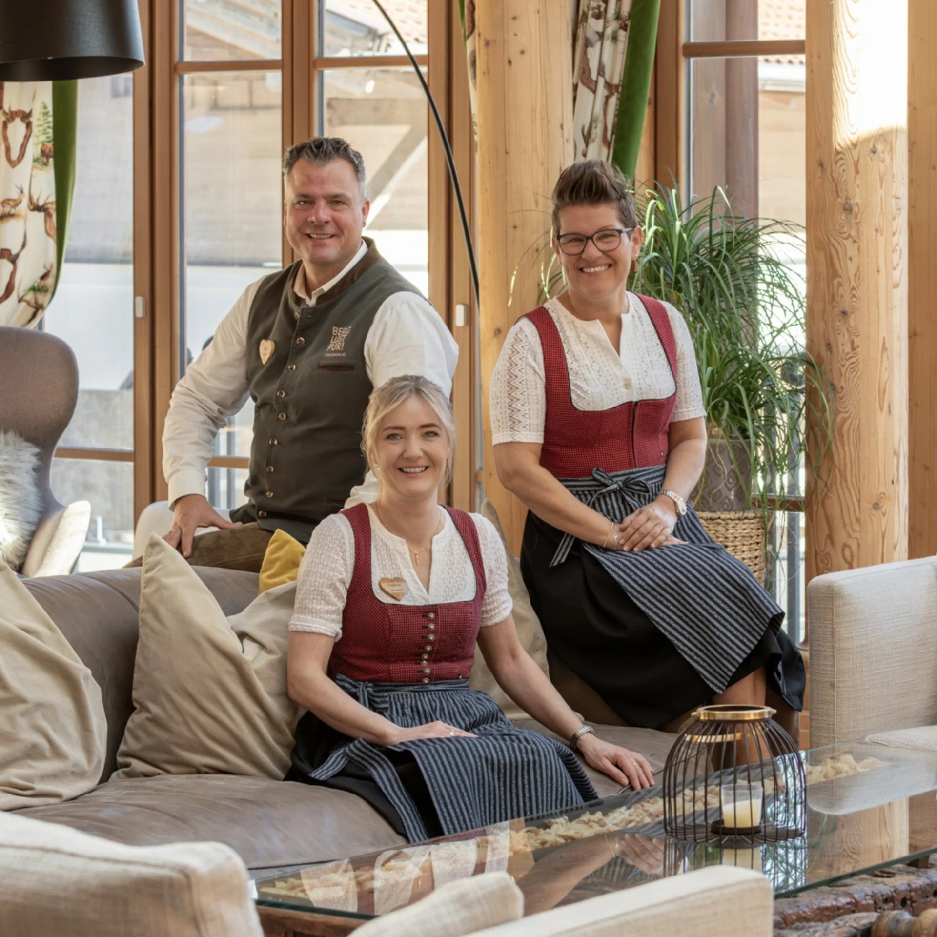 Four people in traditional attire in a wooden interior room