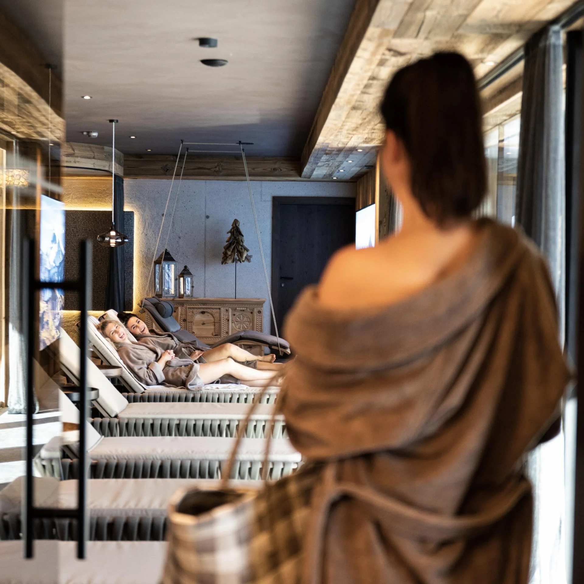 People in robes relaxing in a modern spa lounge relaxation area