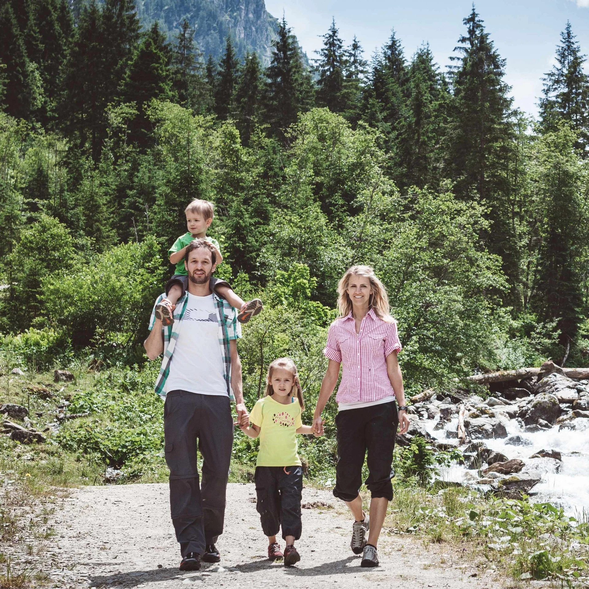 Familien.Zeit Familie mit zwei Kindern wandert im Bergwald an einem sonnigen Tag